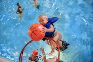 Child in pool with a basketball