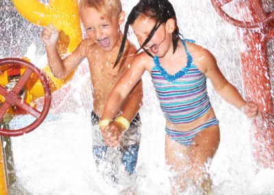 Two kids laughing playing in the water together