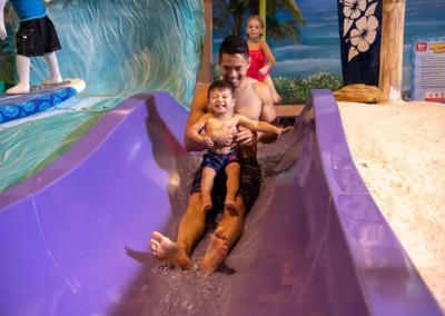 Dad and son sliding down a water slide