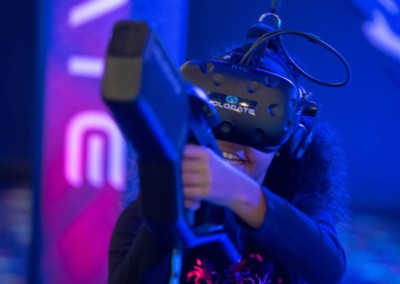 Girl wearing Hologate VR headset and pointing gun prop
