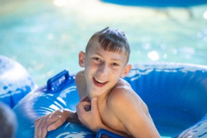 kid smiling while in a tube on the lazy river